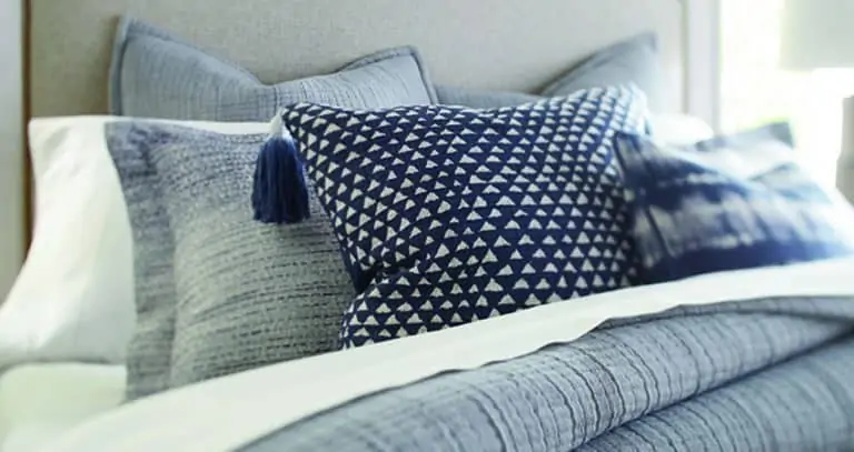 set of navy and white pillows on bed