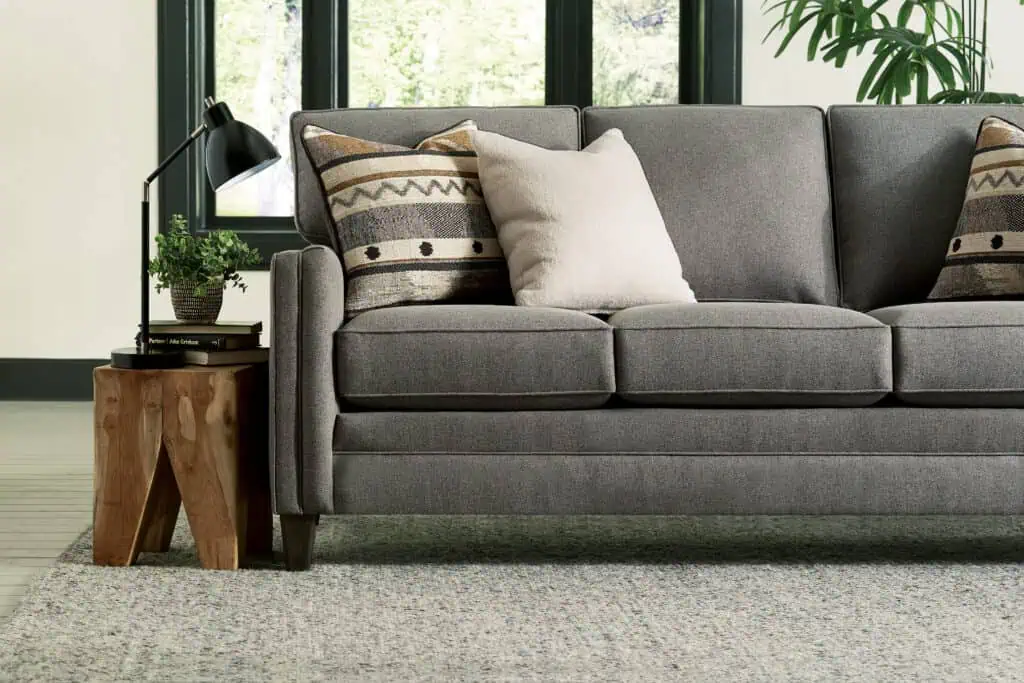 Smith Brother grey sofa with end table and decorative pillows