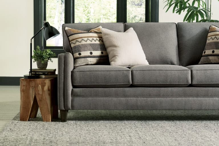 Smith Brother grey sofa with end table and decorative pillows