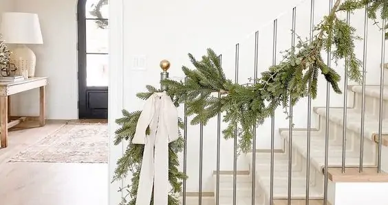 Minimal Christmas garland on staircase with one white bow