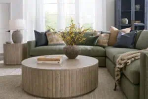 green performance fabric sectional with throw pillows, blanket, and centered coffee table