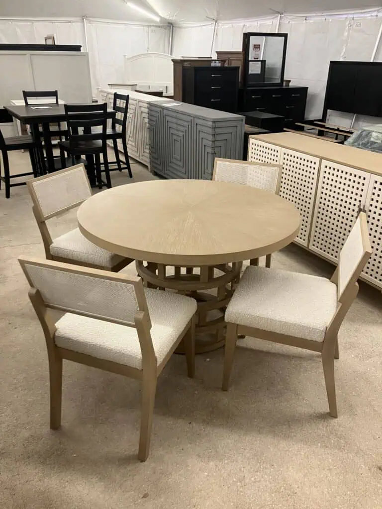 light wood circular dining table with four chairs