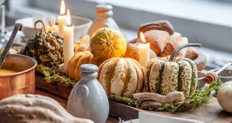 group of pumpkins and candles sitting on table