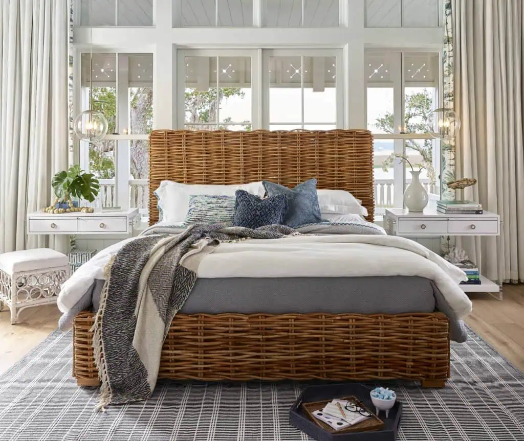 coastal inspired wicker bed frame with navy and white accent bed linens and decorated side tables