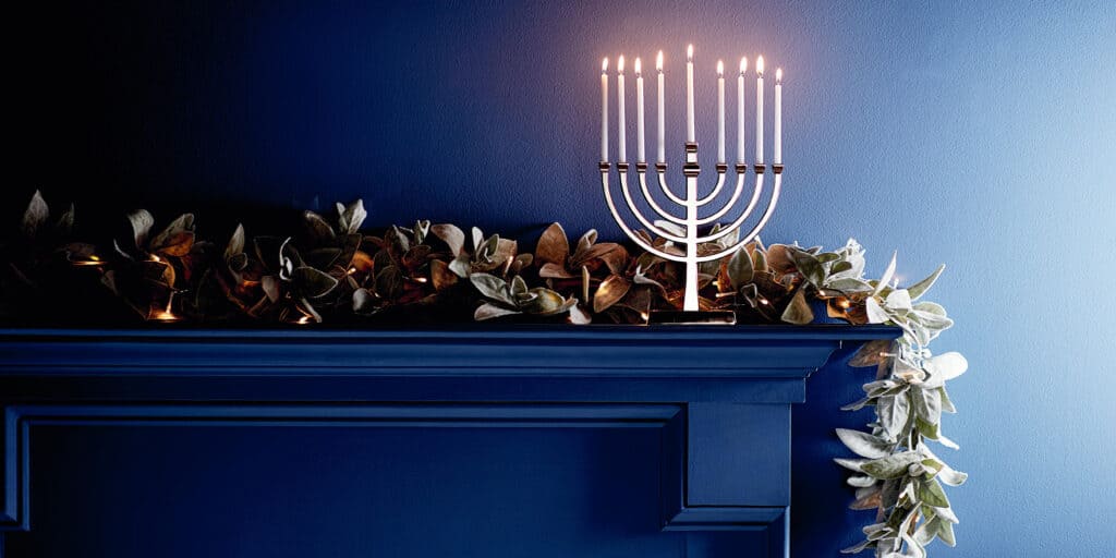 garland on a fireplace with a menorah 