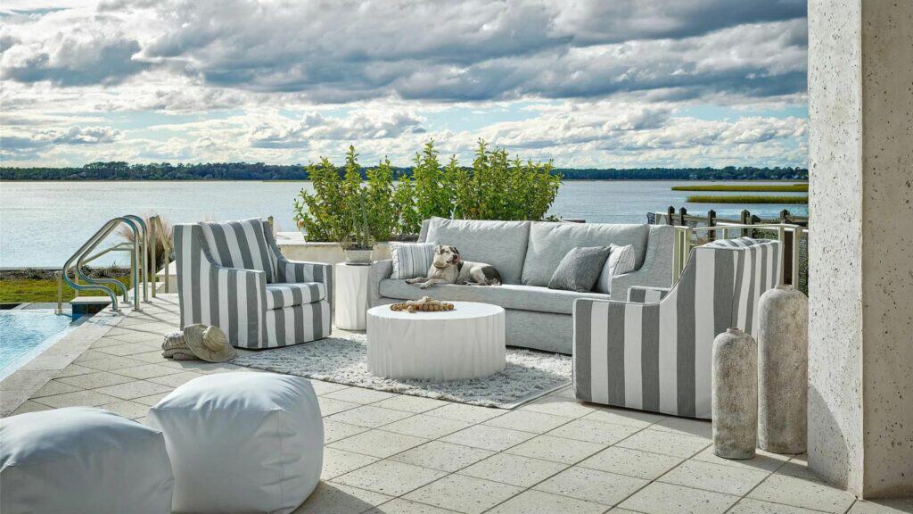 A gray outdoor sofa and two striped arm chairs