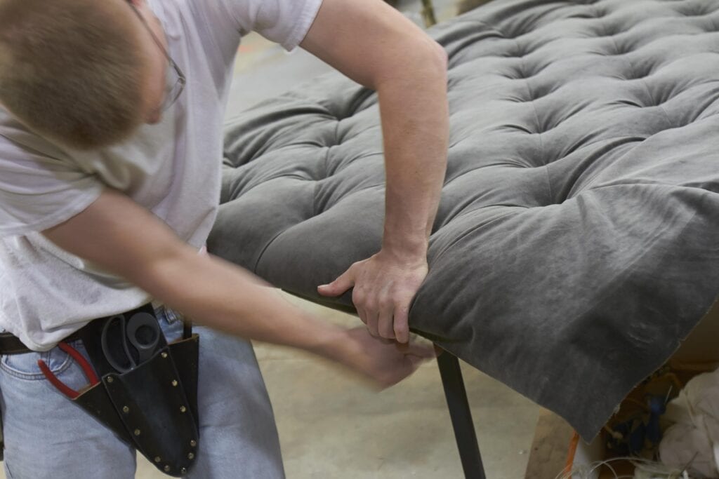 man upholstering a headbord