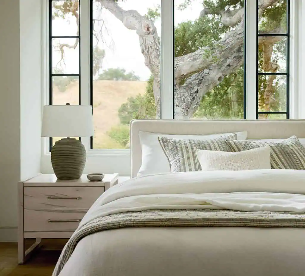 Bassett bedroom scene in front of window with bedside table complete with lamp