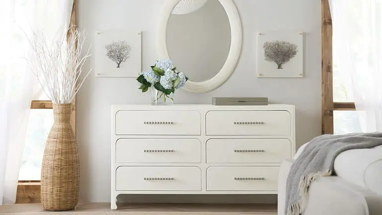 A light colored bedroom dresser and mirror