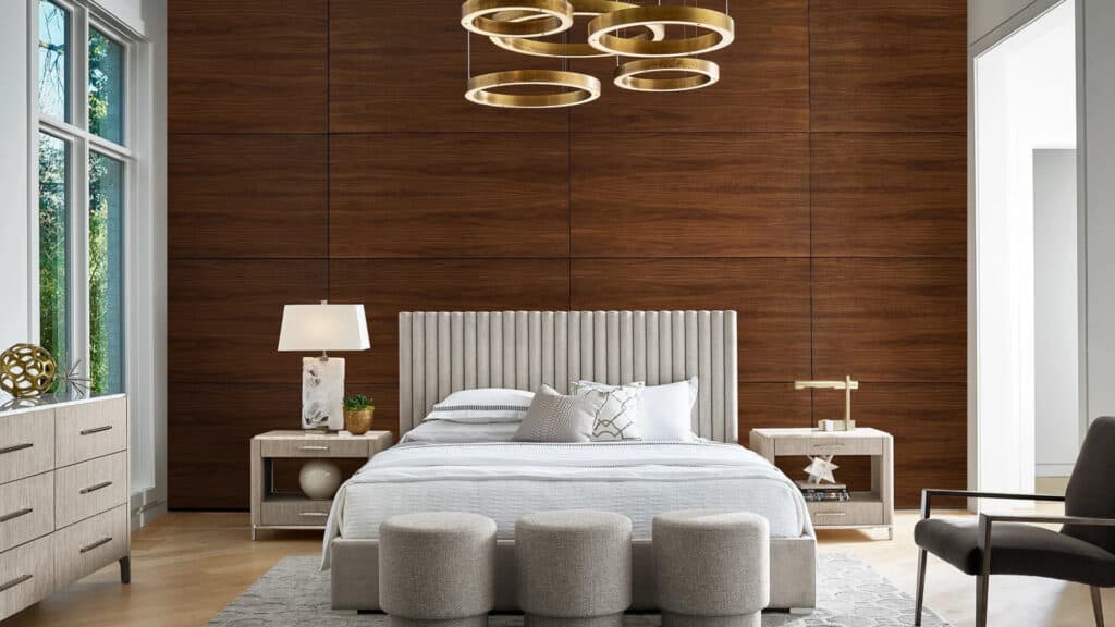 A bedroom with a wood panel wall, a circular light fixture, and circular storage units at the foot of the bed.