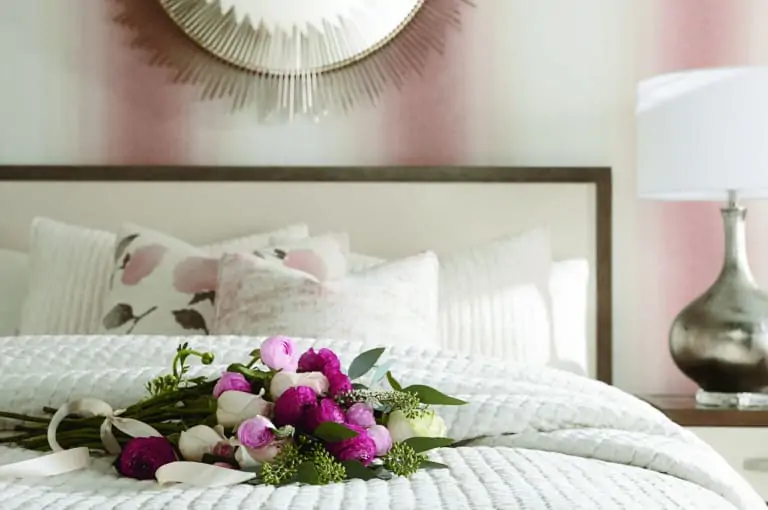 bed with white bedding pink striped wallpaper pink roses