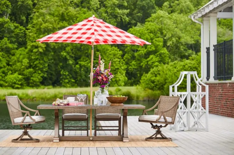 outdoor dining set red umbrella next to lake