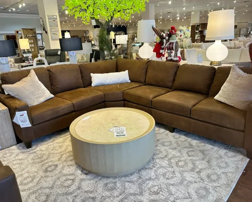 A modern sectional couch paired with a sleek coffee table, showcased in a retail furniture environment.