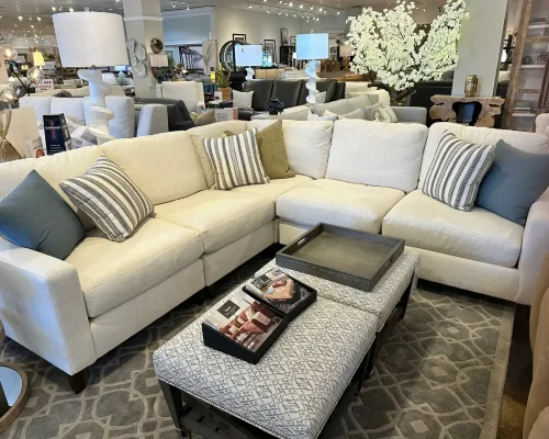 A spacious sectional sofa and matching ottoman showcased in a retail furniture environment.