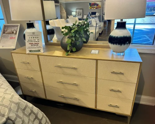 A dresser featuring a large mirror and two elegant lamps, enhancing the room's decor and functionality.
