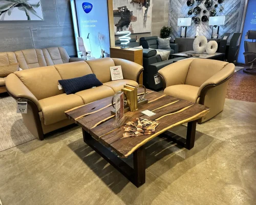 A cozy living room featuring a couch, coffee table, and chairs arranged for relaxation and socializing.