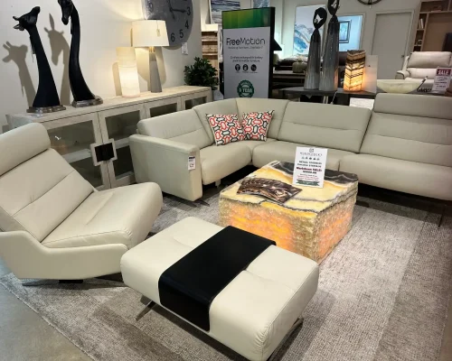 A large sectional sofa with an ottoman displayed in a furniture store setting.