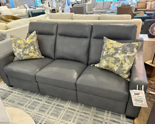 A stylish gray leather sofa with an assortment of colorful pillows, enhancing the comfort of the room.