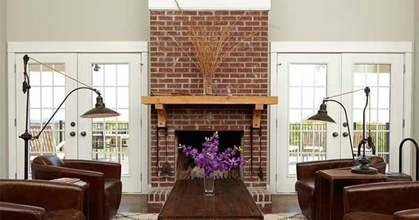 large brick fireplace wood mantle set of leather chairs